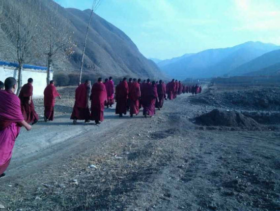 Monks from Labrang Tashikyil monastery walking to the village of Sayi
