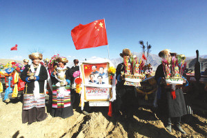 Tibetans in traditional dress bear aloft an image of the Chinese leaders