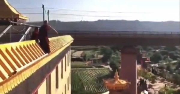 monk threatens to jump off the roof