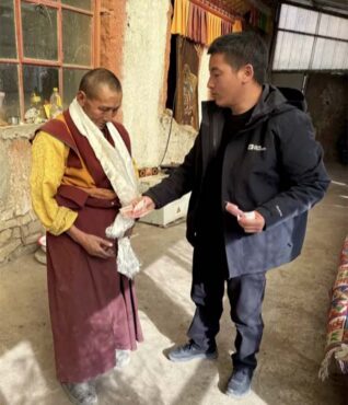 A cadre handing cash to a monastic